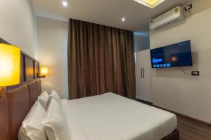 a hotel room with a bed and a flat screen tv at Grand Hotel Annex in Āīzawl +18 photos