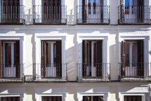 a building with balconies and a reflection in the water at Gran Central Suites in Madrid