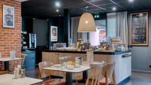 a restaurant with a table and chairs and a counter at Campanile NATURE - Lille Lomme in Lomme