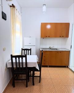 a kitchen with a table and two chairs and a sink at MARE Hotel Velipoje in Shkodër