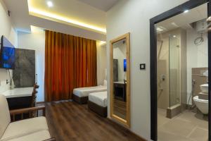 a hotel room with a bathroom with a toilet and a sink at Grand Hotel Annex in Āīzawl