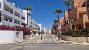 an empty city street with palm trees and buildings at Apartamento junto al mar in Vera