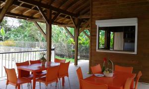 a dining room with a table and chairs on a porch at Gites VASSEAUX in Capesterre-Belle-Eau