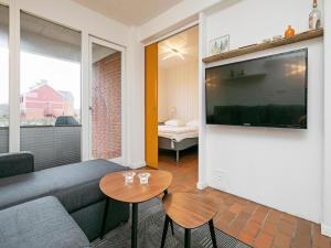 a living room with a couch and a tv at Lemvig Coastal Stay in Lemvig