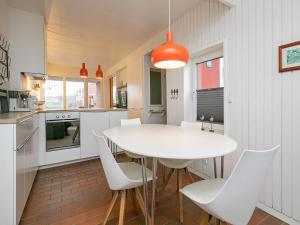 a kitchen with a white table and white chairs at Lemvig Coastal Stay in Lemvig