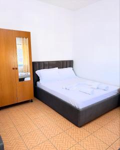 a bedroom with a bed and a wooden door at MARE Hotel Velipoje in Shkodër