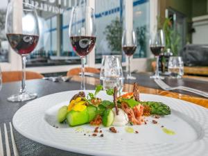 a plate of food on a table with wine glasses at Faaborg Holiday Center in Faaborg