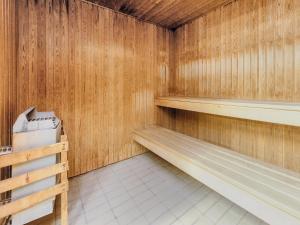 a sauna with wooden walls and a white tile floor at Faaborg Holiday Center in Faaborg