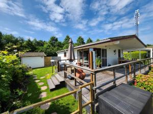a house with a deck and an umbrella at Cozy Chalet in Berkhout