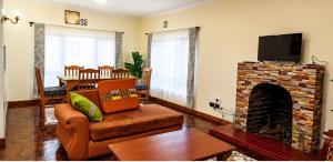 a living room with a couch and a fireplace at Naisula Home in Naivasha
