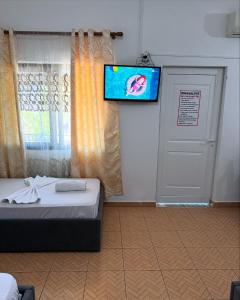 a room with a bed and a flat screen tv at MARE Hotel Velipoje in Shkodër