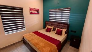 a small bedroom with a bed with red pillows at Rambos Inn Homestay in Vagamon +1 photo