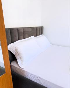 a bed with white sheets and pillows on it at MARE Hotel Velipoje in Shkodër