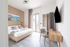 a bedroom with a bed and a table with a chair at Piazza Pertini Rooms in Melendugno