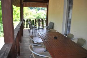 a patio with wooden tables and chairs and a balcony at Agroturystyka nad Sanem in Dydnia