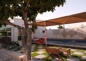 a patio with a hammock under a tent at Sea Turtles Guest House in Al Ḩadd