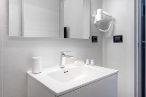 a white bathroom with a sink and a mirror at Piazza Pertini Rooms in Melendugno +52 photos