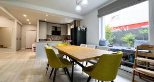 a kitchen and dining room with a wooden table and chairs at Elegant Garden Villa American Village Pipera in Voluntari