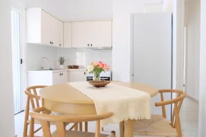 a kitchen with a table with a vase of flowers on it at Lydía Residence - Mantoudi Evia in Mantoúdion