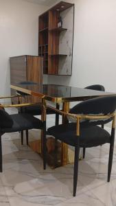 a glass table with black chairs and a mirror at Ike Service Apartments in Owerri +21 photos