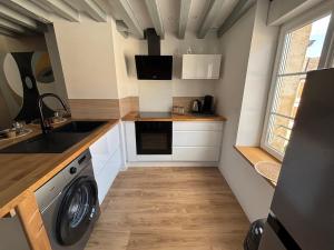 a small kitchen with a washing machine in it at La clé du Temps in Falaise