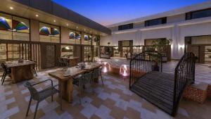a restaurant with tables and chairs in a building at Haldi Kumkum Resort in Limodra