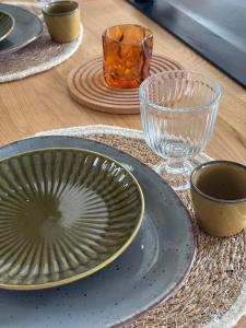 a table with plates and glasses on a wooden table at La clé du Temps in Falaise +17 photos