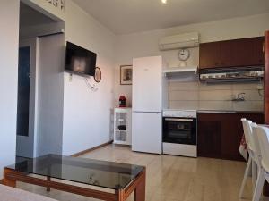 a kitchen with white appliances and a glass table at LASSI Apartment 2 in Argostoli +10 photos