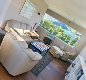 a living room with a white couch and two chairs at Bjarkarholt Guesthouse in Bjarkarholt