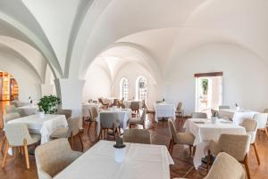 a dining room with white tables and chairs at Ostuni a Mare in Ostuni
