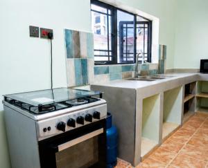 a kitchen with a stove and a sink at Naisula Home in Naivasha