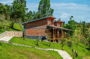 a brick house on a hill with a dog in front at Umutuzo Lodge Kivu Lake in Buhoro