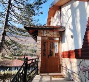 a house with a wooden door on a staircase at Vila Lenka in Rtanj +9 photos