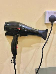 a black hair dryer hanging on a wall at Camp Fire Homestay 2601 in Mersing