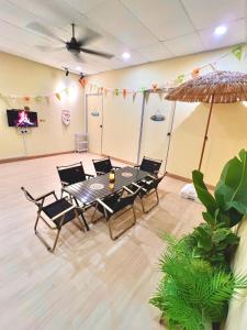 a room with a table and chairs and a tv at Camp Fire Homestay 2601 in Mersing