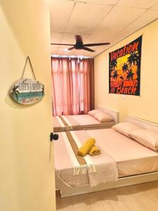 two beds in a room with avertisement for at Camp Fire Homestay 2601 in Mersing