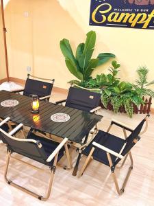 a table with two chairs and a table with two laptops on it at Camp Fire Homestay 2601 in Mersing
