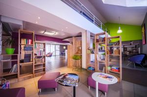 ブリーヴ・ラ・ガイヤルドにあるibis styles Brive Ouestの木製の棚、テーブル、椅子が備わる客室です。