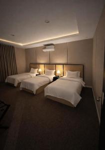 a hotel room with two beds and two lamps at شاليهات حديقة الوسام لبيوت العطلات 1 in Taif +6 photos