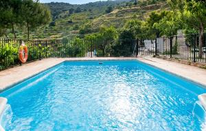 a swimming pool with blue water and a fence at El Museo in Laroya +5 photos