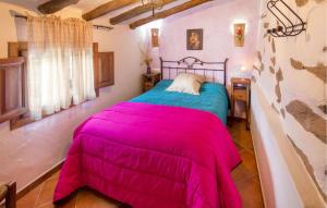 a bedroom with a bed with a pink blanket at El Museo in Laroya