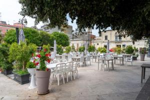 a row of tables and chairs with flowers and plants at Piazza Pertini Rooms in Melendugno