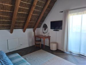 a bedroom with a bed and a table and a tv at 19th Hole Golf Villa Guesthouse in Worcester