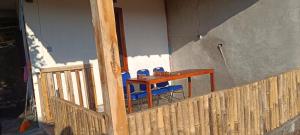 a table and two blue chairs on a porch at Hostel Tetebatu Terrace in Tetebatu