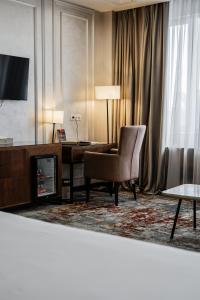 a living room with a chair and a desk at Dostyk Mildom Almaty in Almaty