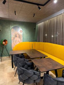 a dining room with two tables and a yellow couch at Complex Turistic Perla Venusului in Venus