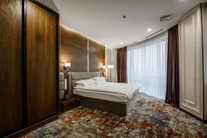 a hotel room with a bed and a large window at Dostyk Mildom Almaty in Almaty