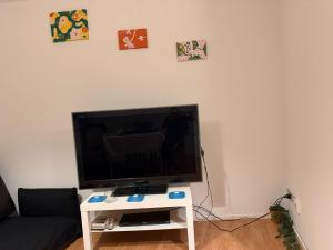 a flat screen tv sitting on top of a white table at City Center big Appartement in St. Gallen