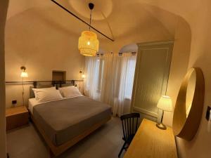 a bedroom with a bed and a table and a lamp at Patossa in Chios