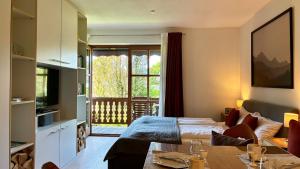 a room with a bed and a table and a window at FeWo Rottachglück in Tegernsee